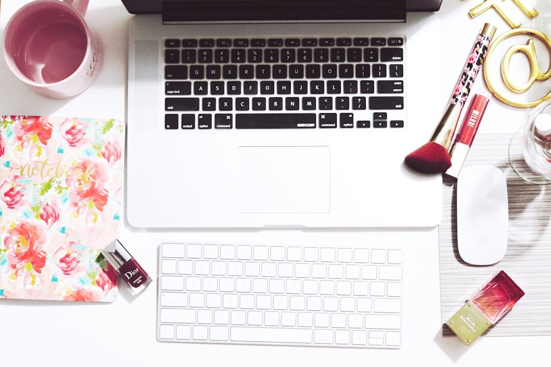 Journalist typing an article on a laptop at a desk with notes